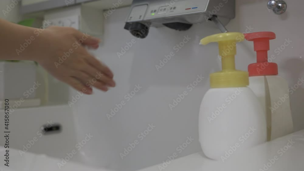 洗面所で手を洗う女性 洗面所で手を洗う女性