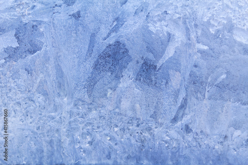 Blue frosty pattern on window glass. Winter background
