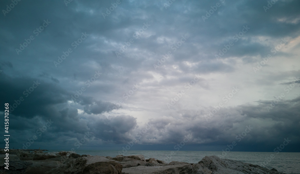 Nubi tempestose che si addensano sul mare all’orizzonte viste dalla scogliera
