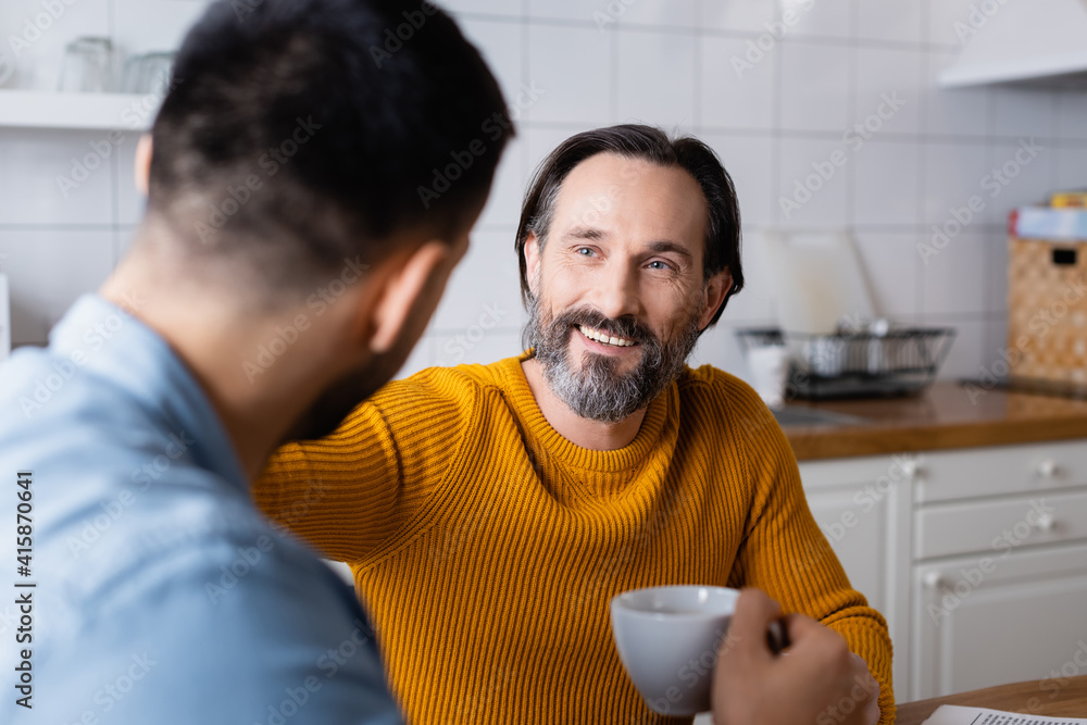 cheerful bearded man talking to young son on blurred foreground cheerful bearded man talking to young son on blurred foreground