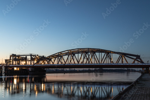 Dutch blue illuminated bridge, IJsselspoorbridge (Zutphen) over the high water of the river 'de ijssel'. photo