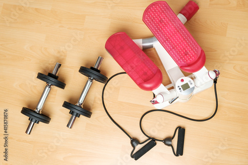 Fotografie Dumbbells and twister stepper on the floor at home
