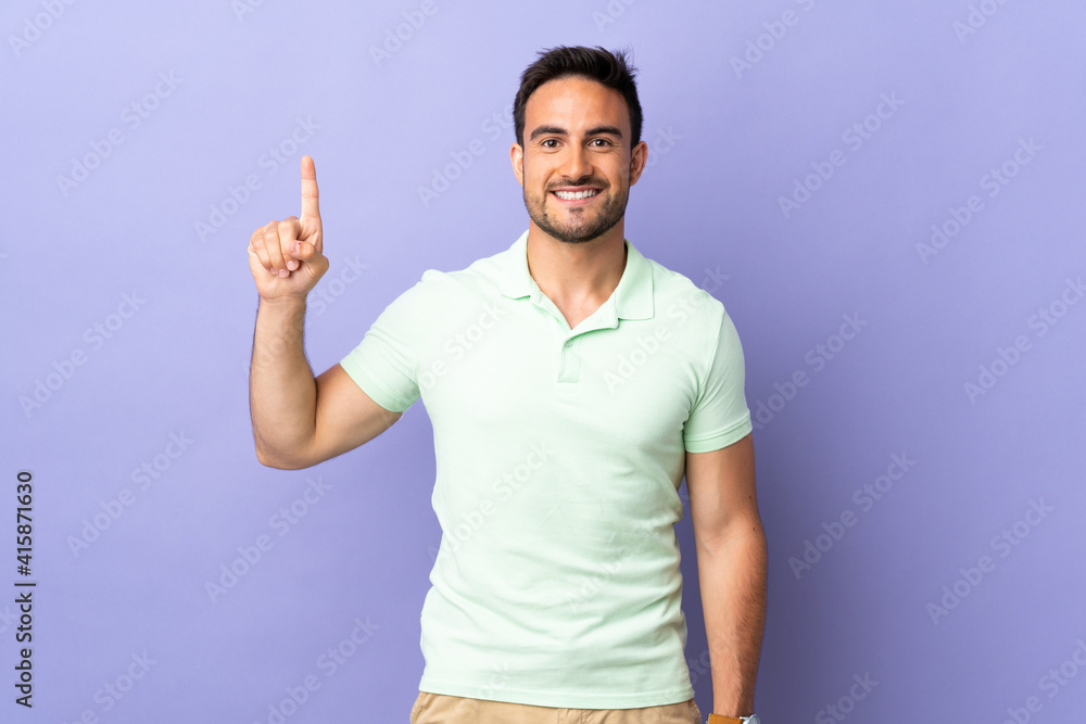 Young handsome man isolated on purple background pointing up a great idea Young handsome man isolated on purple background pointing up a great idea