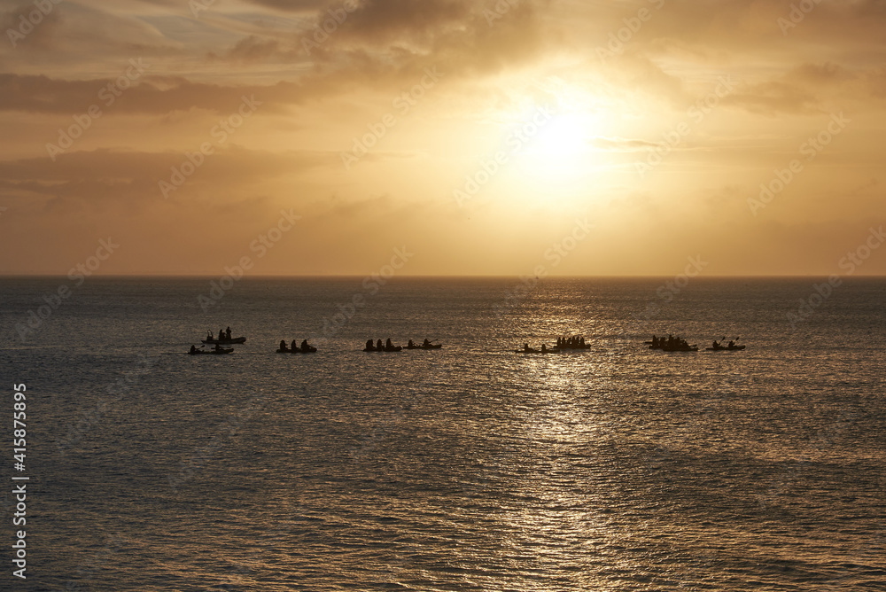 Sonnenaufgang am Meer mit Paddlern in Schlauchbooten
