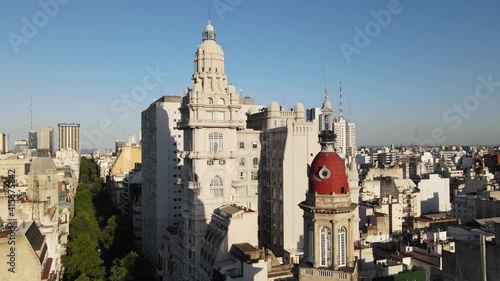 Aerial rising over Barolo palace tower in tree-lined May Avenue surrounded by Monserrat buildings at sunset, Buenos Aires photo