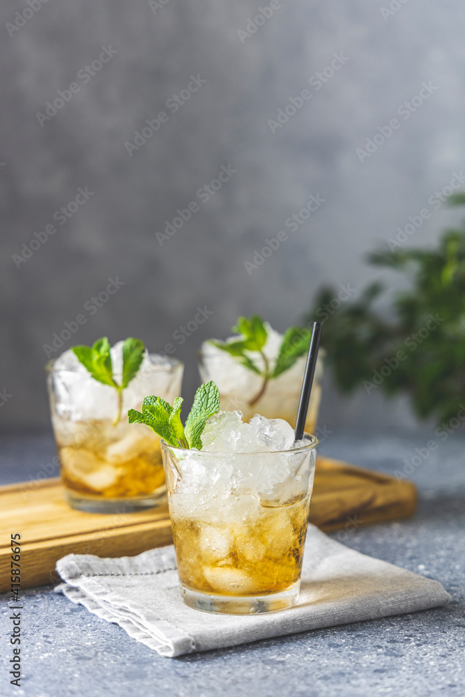 Cold summer beverage, mint julep cocktail drink, grey stone background copy space Cold summer beverage, mint julep cocktail drink, grey stone background copy space