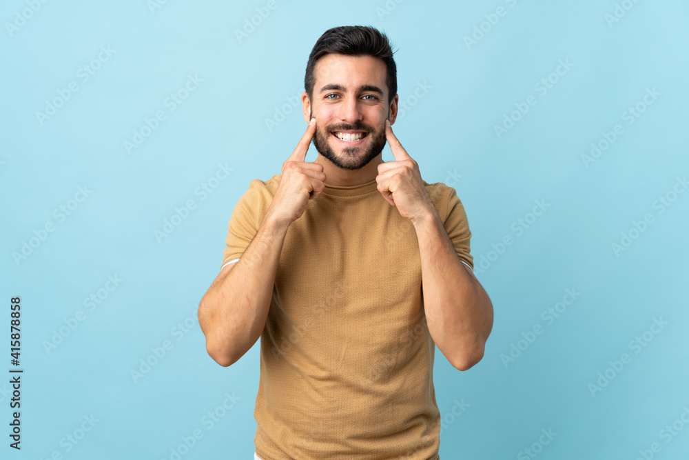 Naklejka premium Young handsome man with beard over isolated background smiling with a happy and pleasant expression