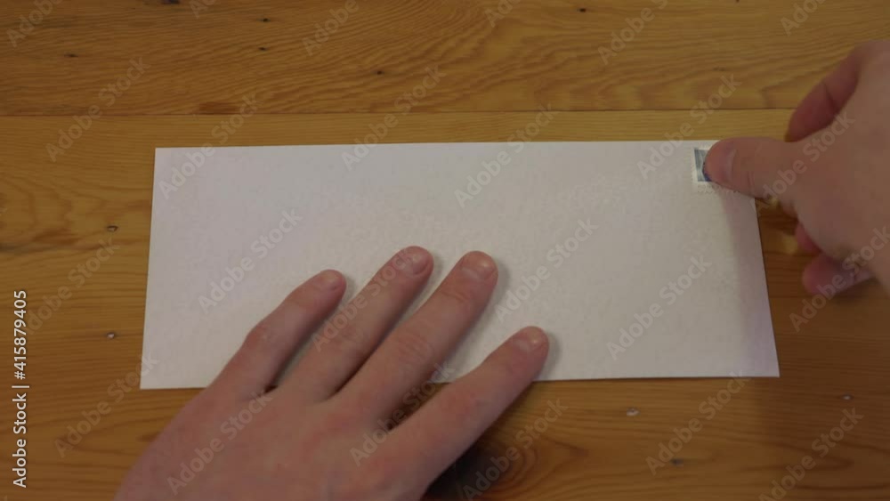 Man Places Stamp on Blank Envelope, First Person Point of View Man Places Stamp on Blank Envelope, First Person Point of View
