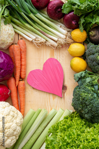 To take care of your diet, consuming too many vegetables to protect your heart. Heart and various vegetables on the table.