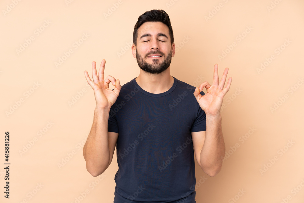 Caucasian handsome man isolated on beige background in zen pose Caucasian handsome man isolated on beige background in zen pose
