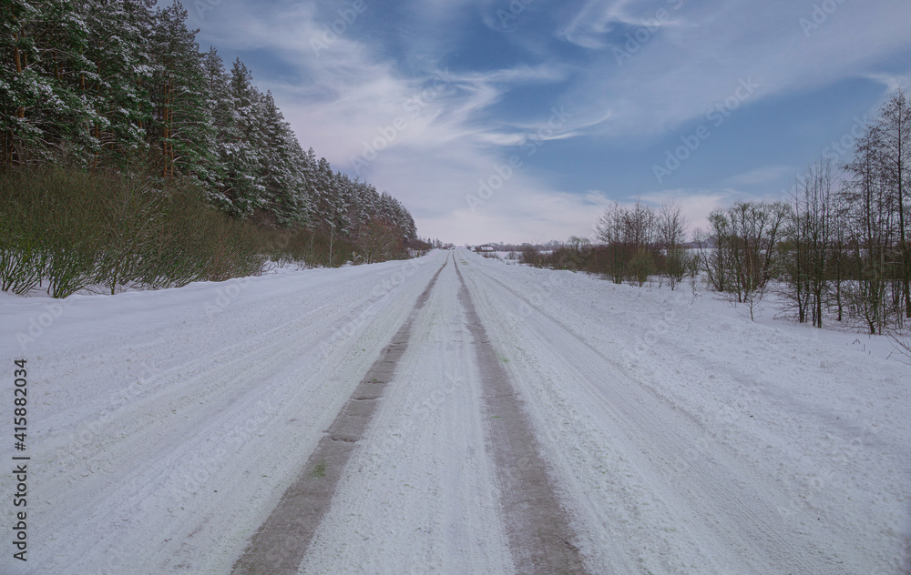 a road passing the edge of the forest.winter in the russian federation a road passing the edge of the forest.winter in the russian federation