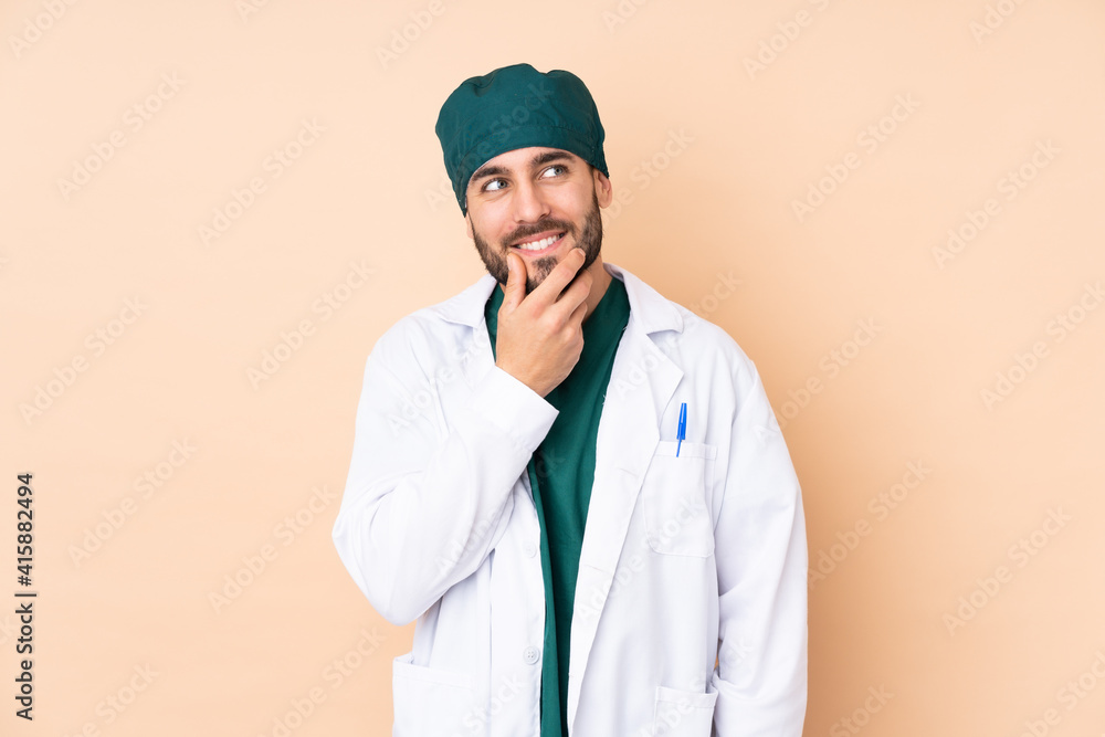 Surgeon man isolated on beige background thinking an idea Surgeon man isolated on beige background thinking an idea