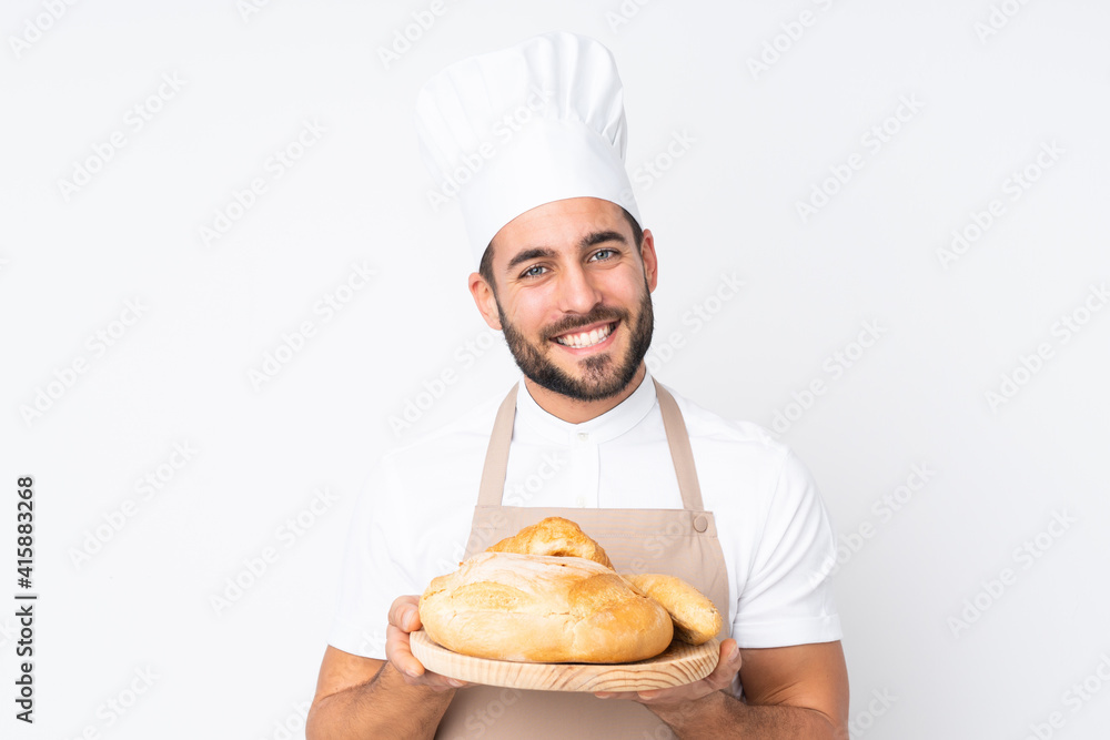 Male baker holding a table with several breads isolated on white background Male baker holding a table with several breads isolated on white background