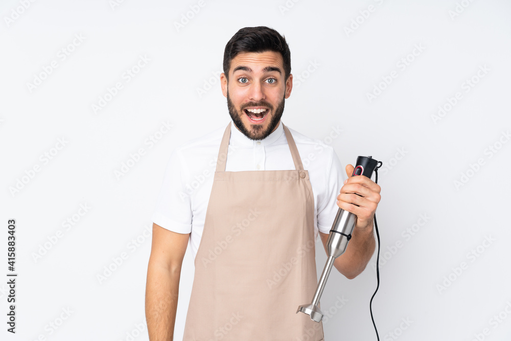 Man using hand blender isolated on white background with surprise facial expression Man using hand blender isolated on white background with surprise facial expression