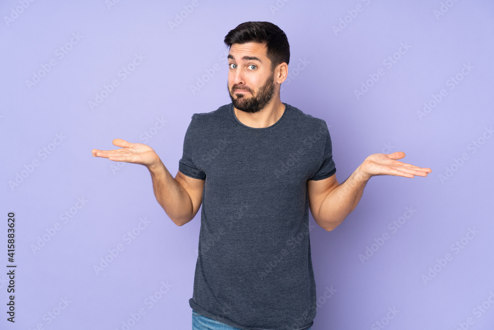 Caucasian handsome man having doubts while raising hands over isolated purple background Caucasian handsome man having doubts while raising hands over isolated purple background