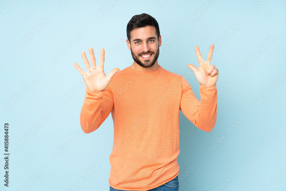 Caucasian handsome man counting eight with fingers over isolated blue background Caucasian handsome man counting eight with fingers over isolated blue background