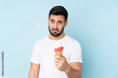 Caucasian man with a cornet ice cream isolated on blue background