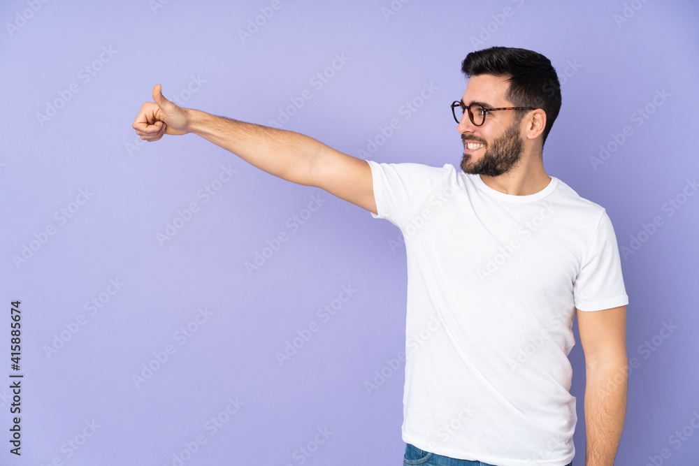 Caucasian handsome man over isolated background giving a thumbs up gesture Caucasian handsome man over isolated background giving a thumbs up gesture