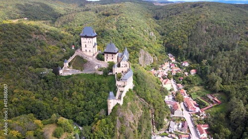 Aerial view on royal castle Karlstejn medieval, state owned castle near Prague in spring nature, lit by evening sun. Romantic Czech castle on the hilltop. Central Bohemia, czech landscape, Czechia