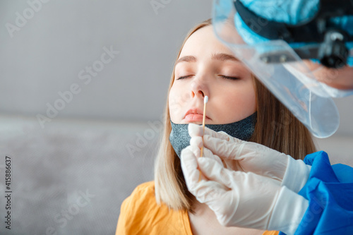 Diagnostics testing patients coronavirus covid 19. Doctor in protective medical mask taking PCR test nasopharyngeal culture to woman. Nurse take test through nose with cotton swab. Copy space photo