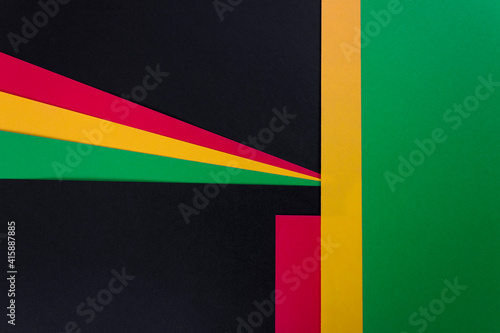 Red, yellow and green color paper on the black background. Black History Month concept. Flat lay. Copy space.