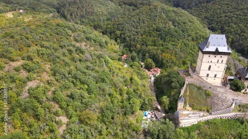 Aerial view on royal castle Karlstejn medieval, state owned castle near Prague in spring nature, lit by evening sun. Romantic Czech castle on the hilltop. Central Bohemia, czech landscape, Czechia
