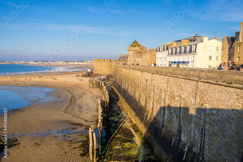 Saint-Malo, France - August 25, 2019: Beach in the evening sun and Historic wall of the old city of Saint-Malo, Brittany on the English Channel coast