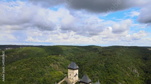 Aerial view on royal castle Karlstejn medieval, state owned castle near Prague in spring nature, lit by evening sun. Romantic Czech castle on the hilltop. Central Bohemia, czech landscape, Czechia