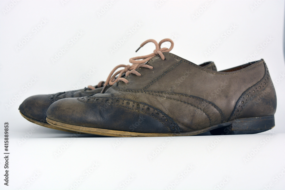 Female leather shoes located on a white background. Oxford shoes with gray shoelaces on a flat heel. Gray women's shoes in a fastening, unwitting. Female leather shoes located on a white background. Oxford shoes with gray shoelaces on a flat heel. Gray women's shoes in a fastening, unwitting.