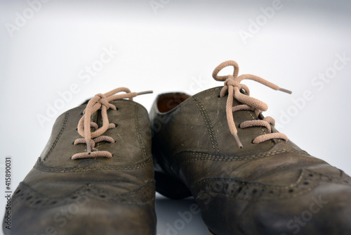 Female leather shoes located on a white background. Oxford shoes with gray shoelaces on a flat heel. Gray women's shoes in a fastening, unwitting. 