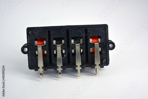 Black electric plastic box for fixing wires with red and black clamps for simultaneous connection of bare wires located on a white plastic background.  photo