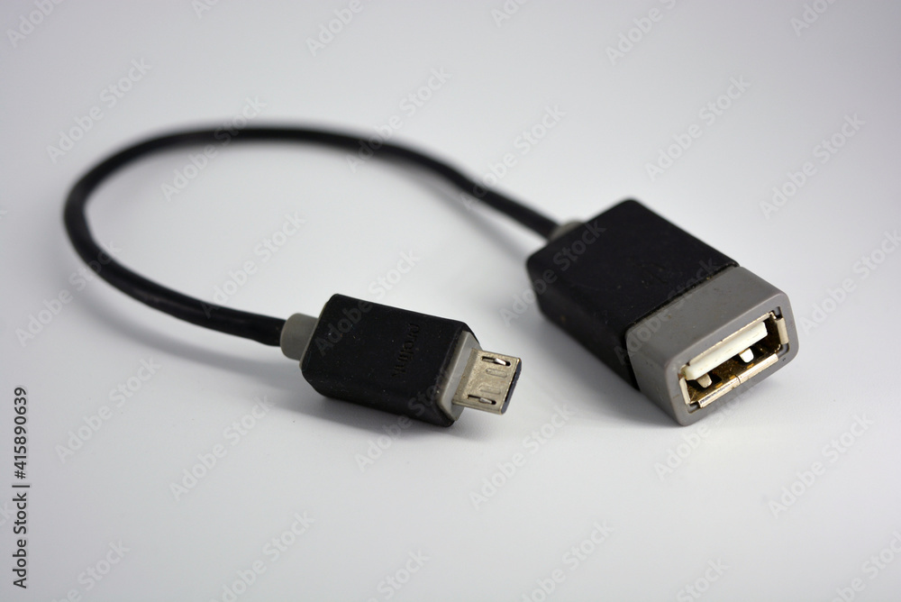 Adapter black wire for computer and phone is located on a white plastic background. Adapter black wire for computer and phone is located on a white plastic background.