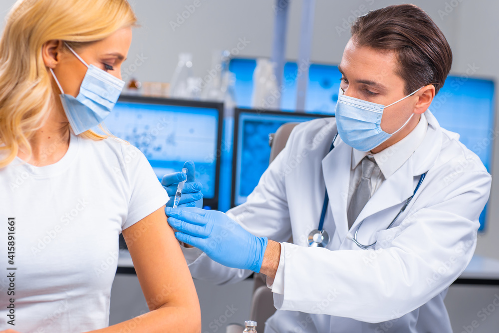 Professional doctor makes a coronavirus vaccine using a syringe and hypodermic needle. Professional medical worker and patient at the hospital office. Vaccination and safety. Professional doctor makes a coronavirus vaccine using a syringe and hypodermic needle. Professional medical worker and patient at the hospital office. Vaccination and safety.