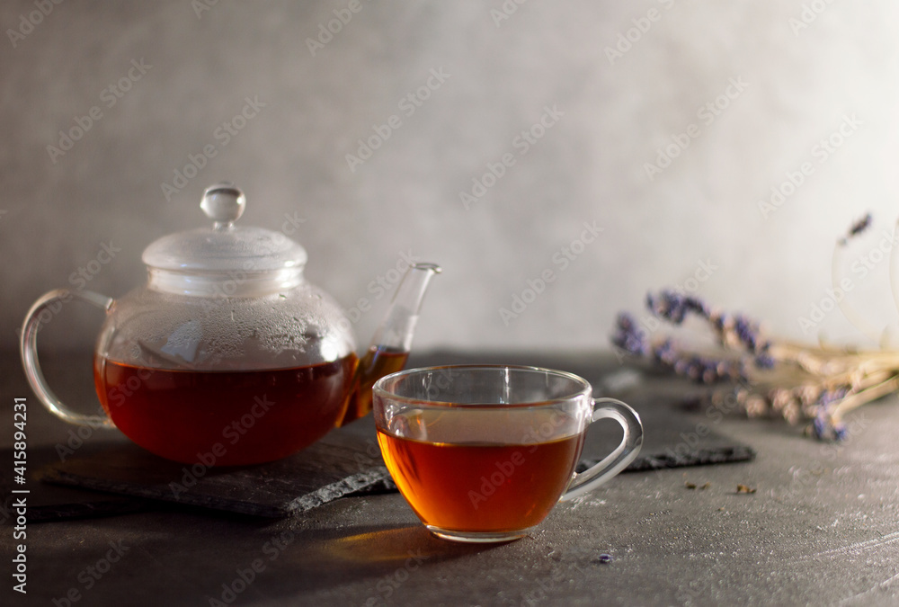 a teapot and a cup of tea, the teapot stands on a basalt stand a teapot and a cup of tea, the teapot stands on a basalt stand
