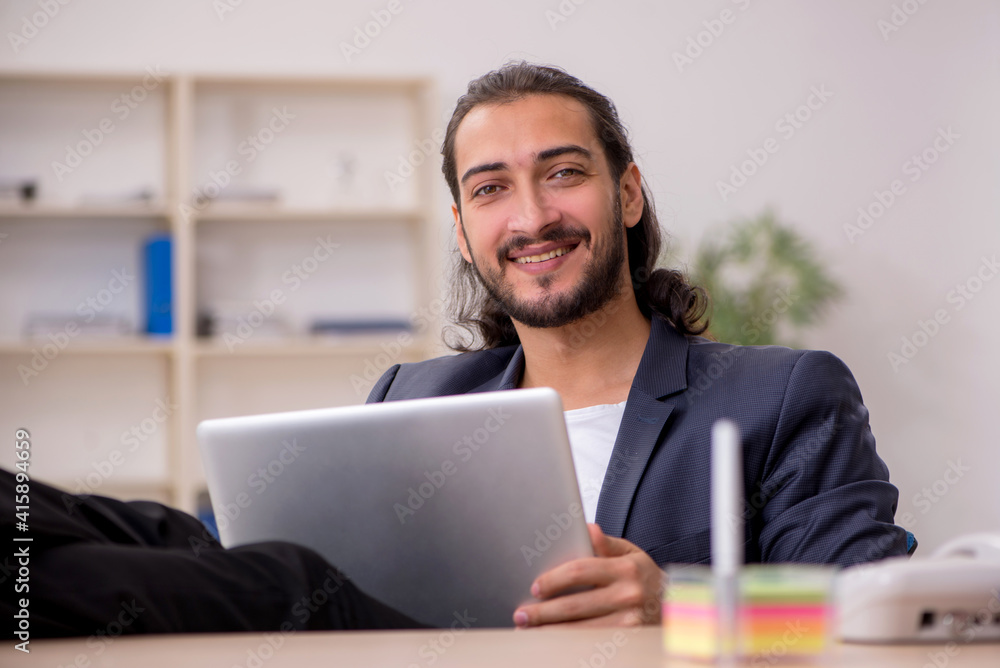 Young male employee working in the office Young male employee working in the office