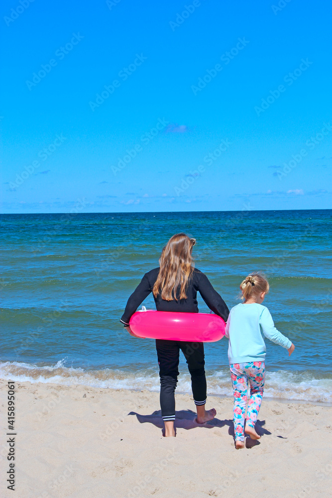Children go to swim in sea. Little sisters enjoying summer holidays Children go to swim in sea. Little sisters enjoying summer holidays