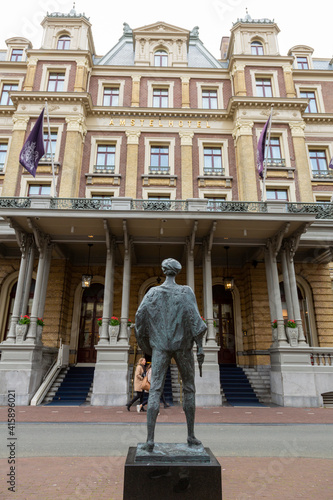Europe, Netherlands, Amsterdam. Back of statue of young Rembrandt and Amstel Hotel.