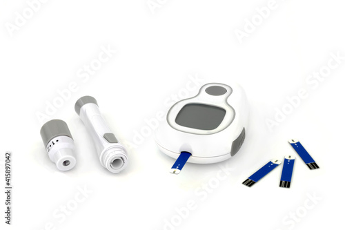 Diabetes monitoring and testing equipment kit with blood glucose monitor meter, lancing device & tester strip. On white background.