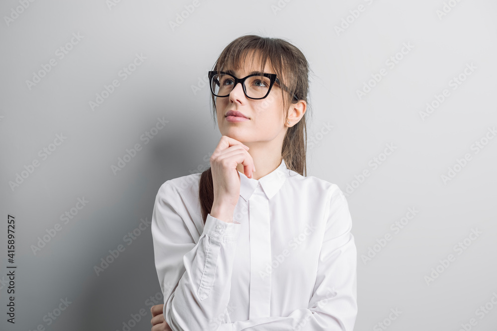 Portrait of a young woman thinking over an idea. Pensive student with glasses. Portrait of a young woman thinking over an idea. Pensive student with glasses.