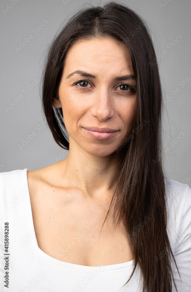 Attractive young adult woman looks towards camera with neutral expression
Attractive young adult woman looks towards camera with neutral expression