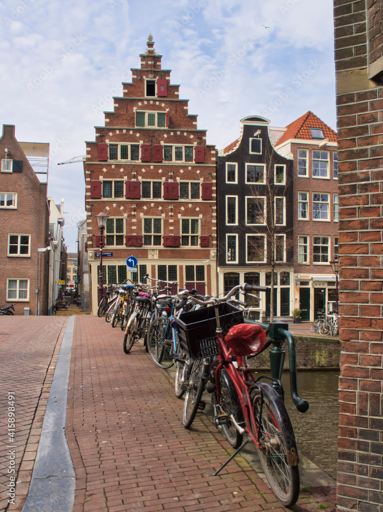 Netherlands, Amsterdam. Traditional houses along the canal lined with bicycles.