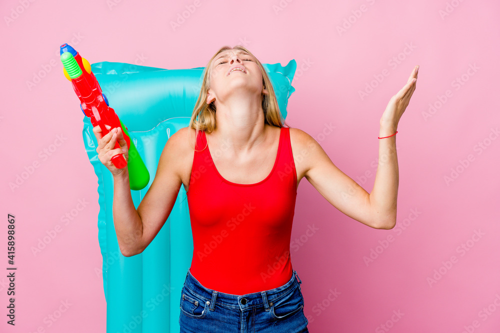 Young russian woman playing with a water gun with an air mattress screaming to the sky, looking up, frustrated. Young russian woman playing with a water gun with an air mattress screaming to the sky, looking up, frustrated.