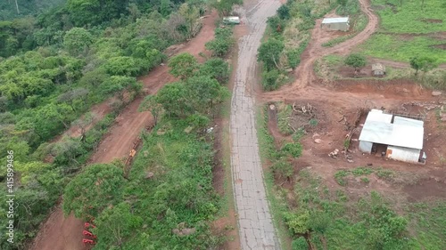 Panning up to the building facing Calandula waterfalls in Angola, road, and hills leading to the waterfall in the distance.  Aerial photo