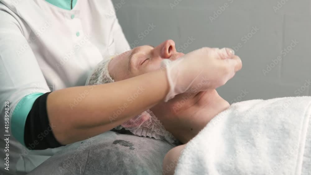 Professional skin care with massage. Women's hands in gloves. A man takes care of the skin of the face. Professional skin care with massage. Women's hands in gloves. A man takes care of the skin of the face.