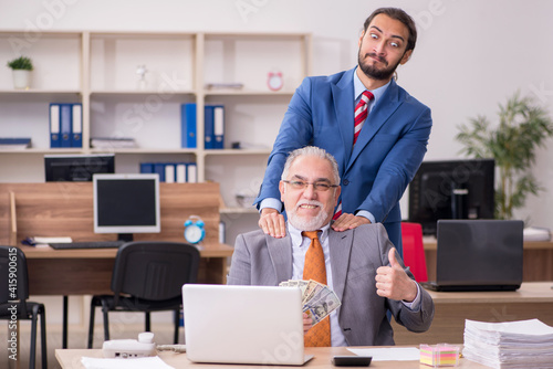 Old male boss and young male employee in remuneration concept