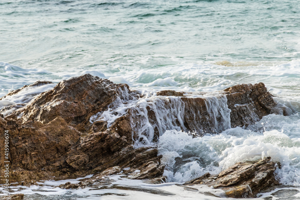 closeup of wave gently flowing over rock on california coastline; water cascading down the side. Pacific ocean in the background.
closeup of wave gently flowing over rock on california coastline; water cascading down the side. Pacific ocean in the background.