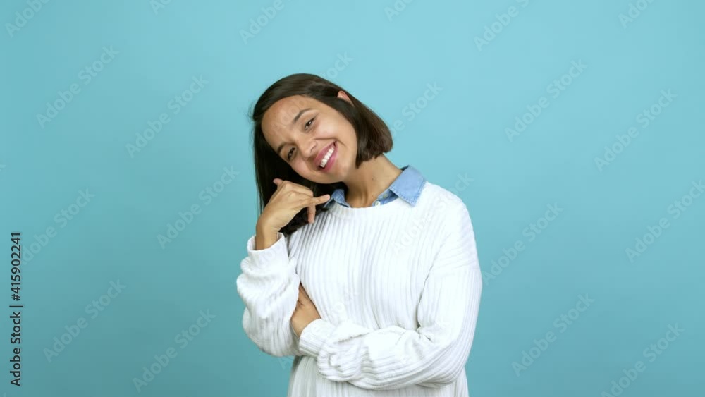 Young brunette woman making phone gesture and speaking with someone. Call me back sign over isolated background Young brunette woman making phone gesture and speaking with someone. Call me back sign over isolated background