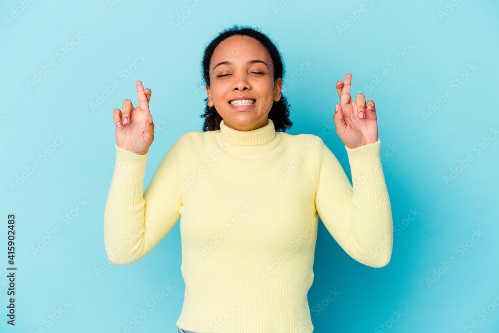 Young african american mixed race woman isolated crossing fingers for having luck Young african american mixed race woman isolated crossing fingers for having luck