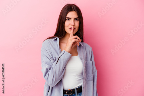 Young caucasian woman isolated on pink background keeping a secret or asking for silence.