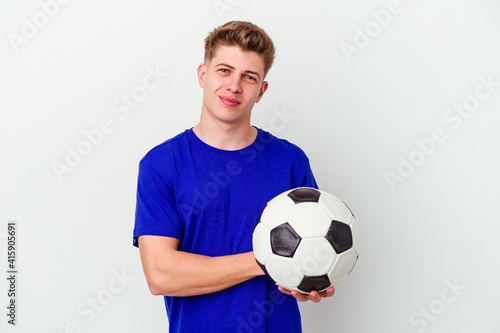 Young caucasian man playing soccer isolated on background laughing and having fun.